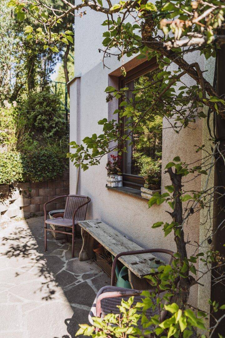 Gemütliche Terrasse mit Sitzgelegenheiten und Blick auf die grüne Umgebung.