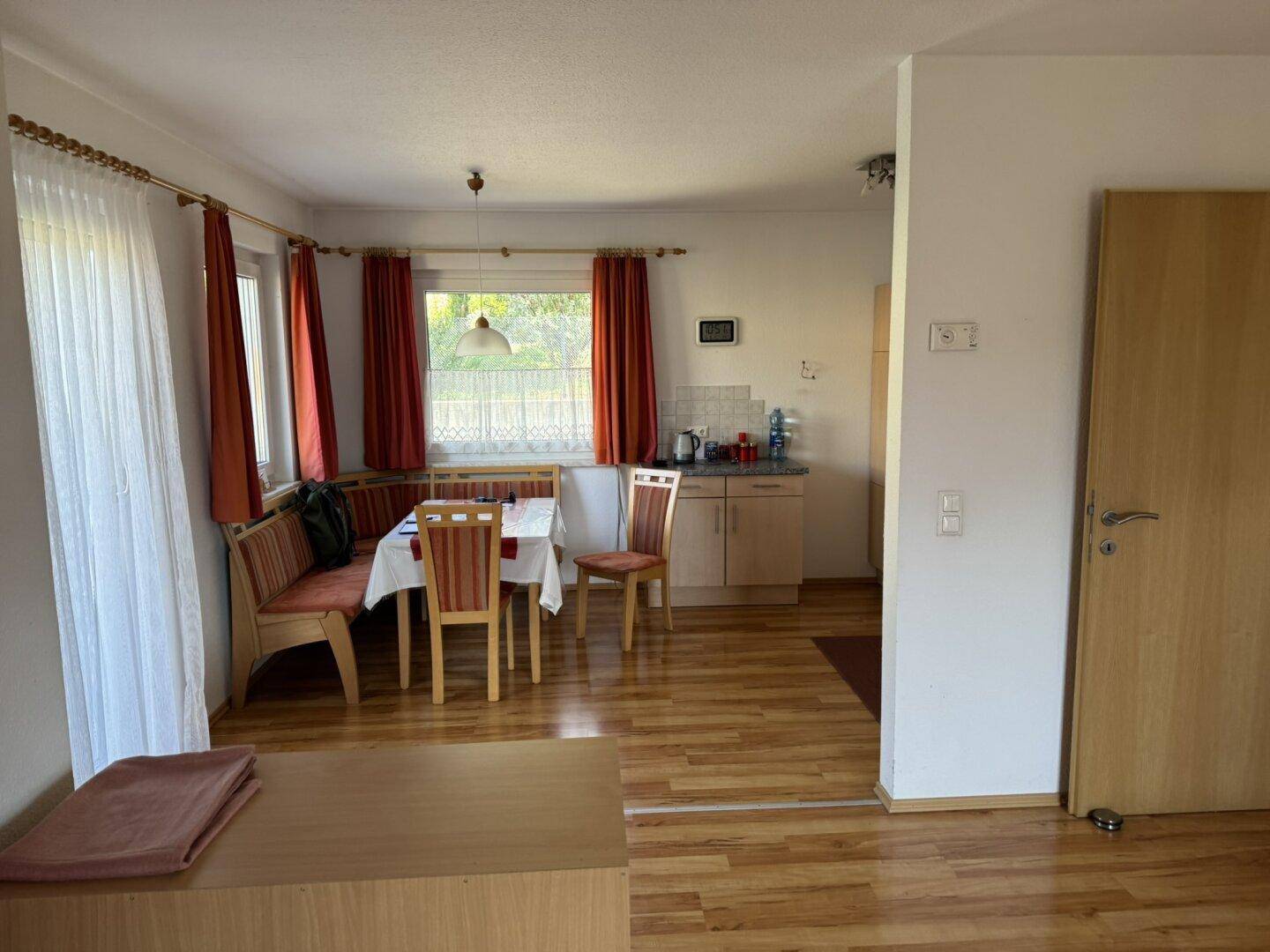 Offener Essbereich mit Eckbank, Laminatboden und Blick in die angrenzende Küche.