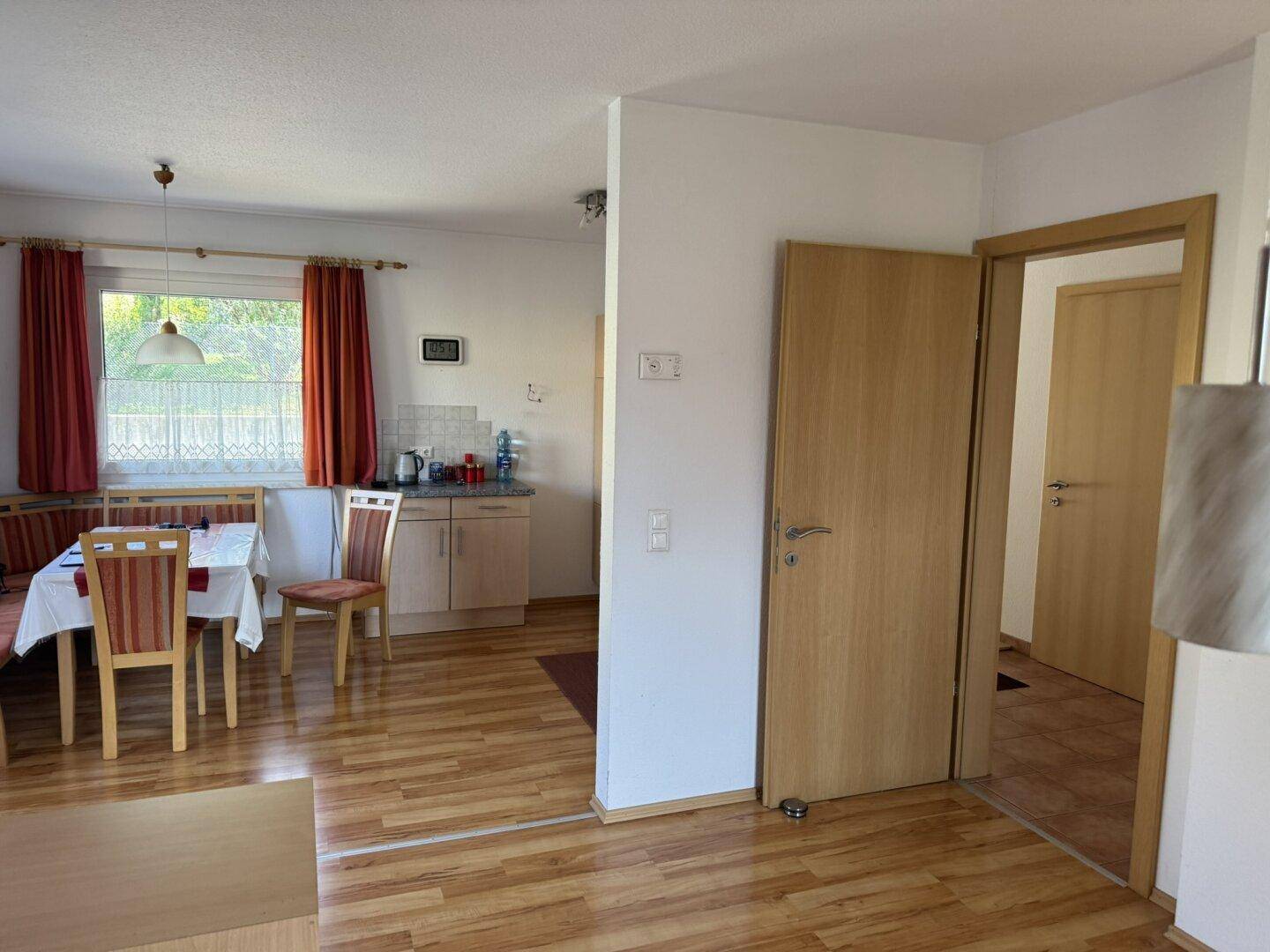 Essbereich mit Laminatboden und Zugang zu weiteren Räumen im Haus.