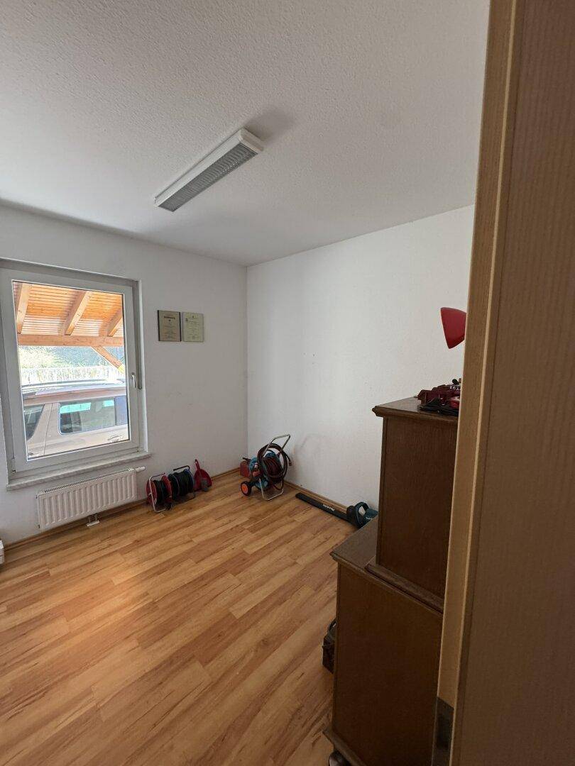 Helles Zimmer mit Laminatboden und Blick nach draußen, ideal als Schlaf- oder Arbeitszimmer.