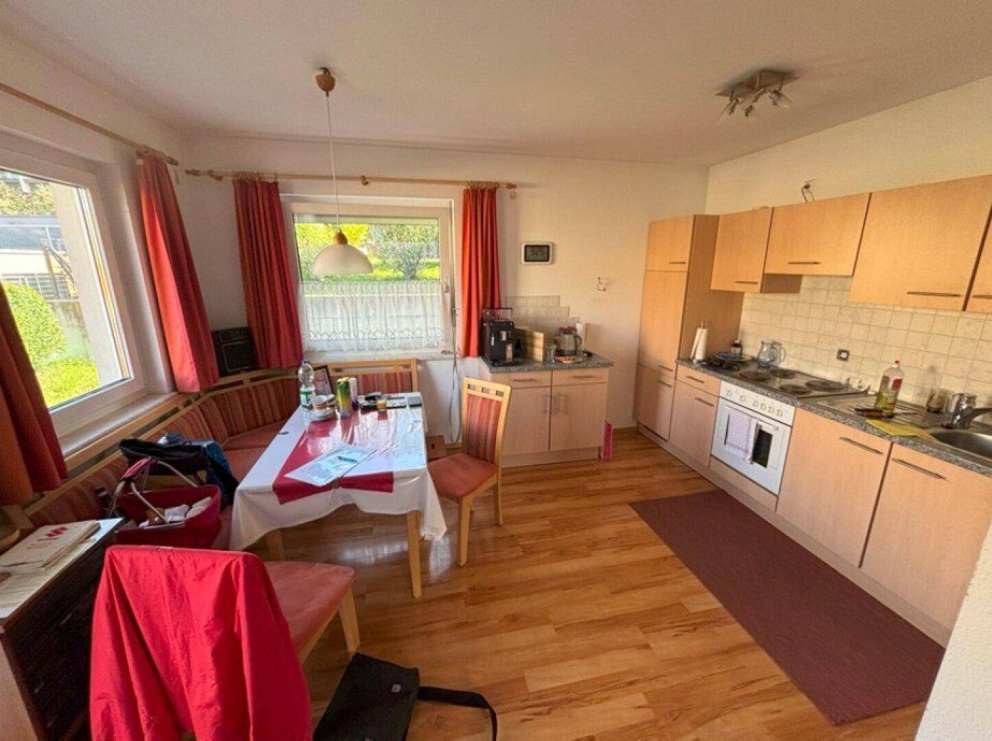 Funktionale Küche mit Essbereich, Laminatboden und Fenster, gut beleuchtet.