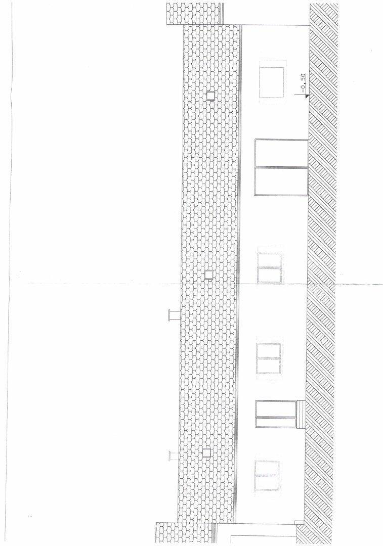 Fassadenansicht des Gebäudes mit Fenstern und Dachüberstand.