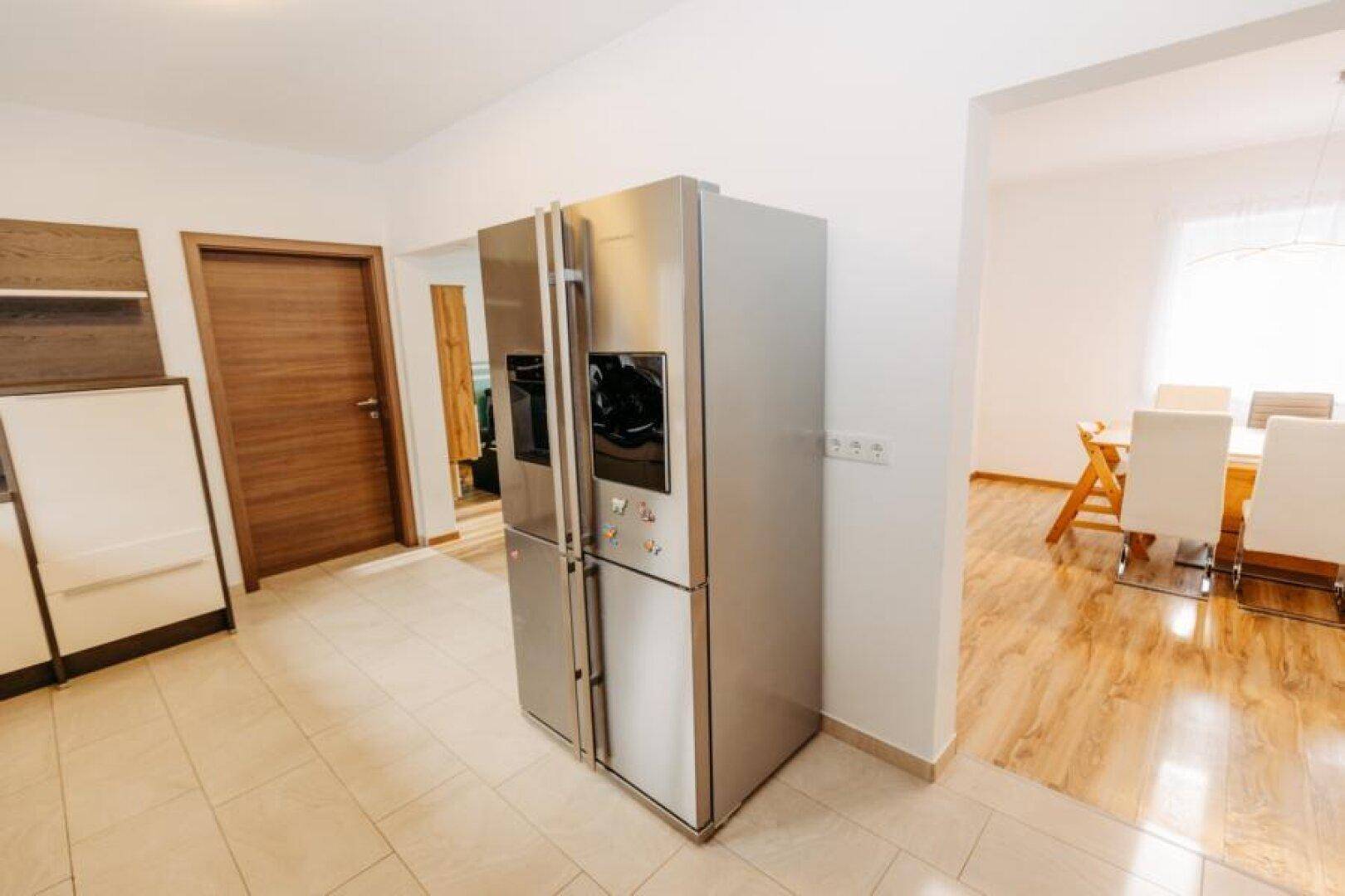 Geräumige Küche mit großem Side-by-Side-Kühlschrank und modernen Einbauschränken.