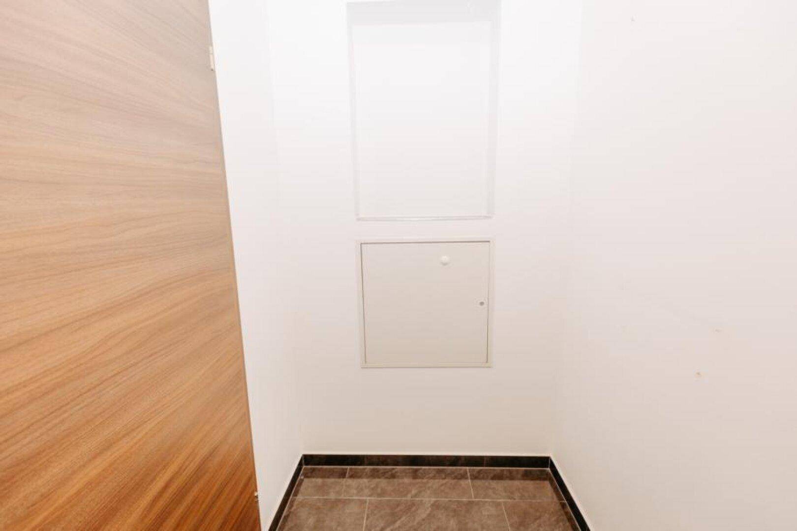 Kleiner Abstellraum oder Nische mit Zugangsklappe, ideal für zusätzlichen Stauraum.