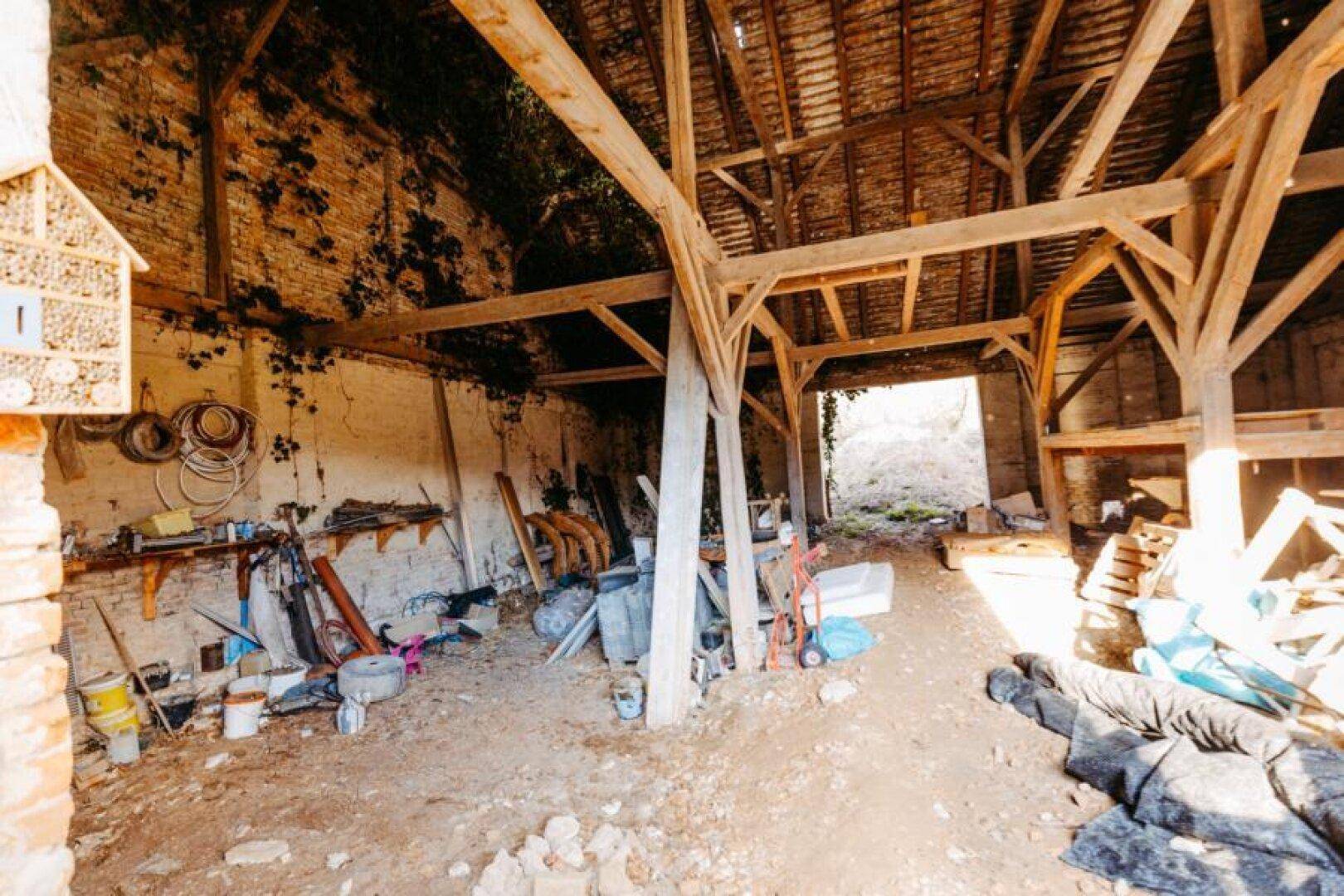 Geräumige Scheune mit freiliegenden Holzbalken, Ziegelwänden und viel Stauraum.