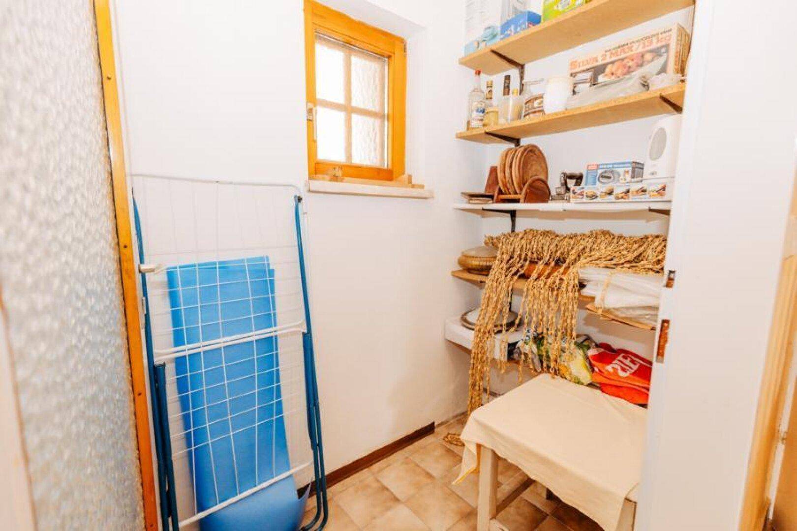 Praktischer Abstellraum mit Regalen, Fenster und Platz für Haushaltsgeräte.