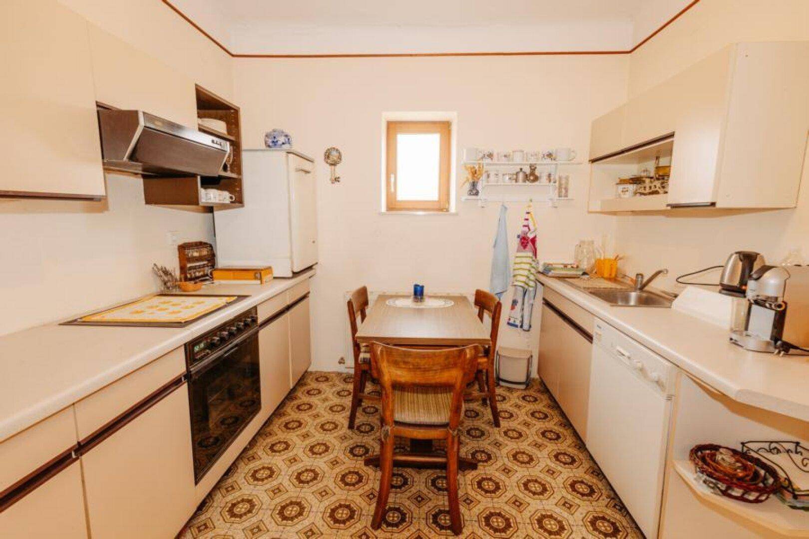 Traditionelle Küche mit Essbereich, Einbauschränken und Fenster für Tageslicht.