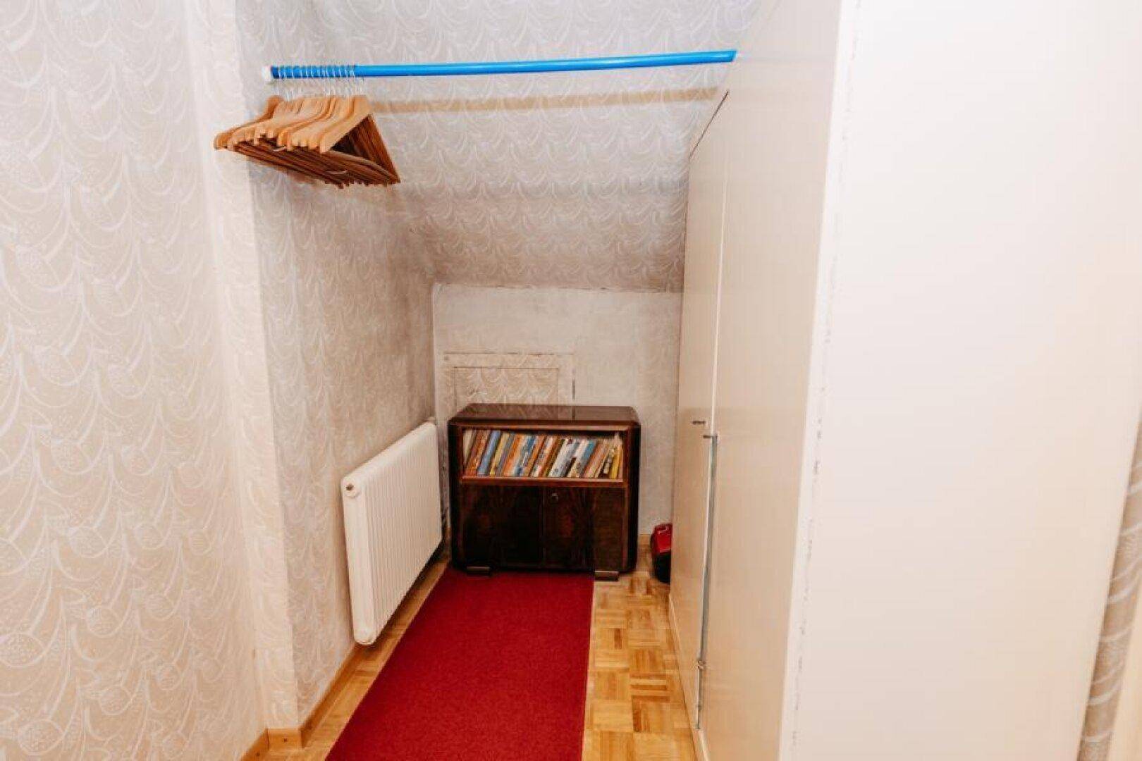 Dachgeschossflur mit Schrägen, Teppichboden und Einbauschränken.