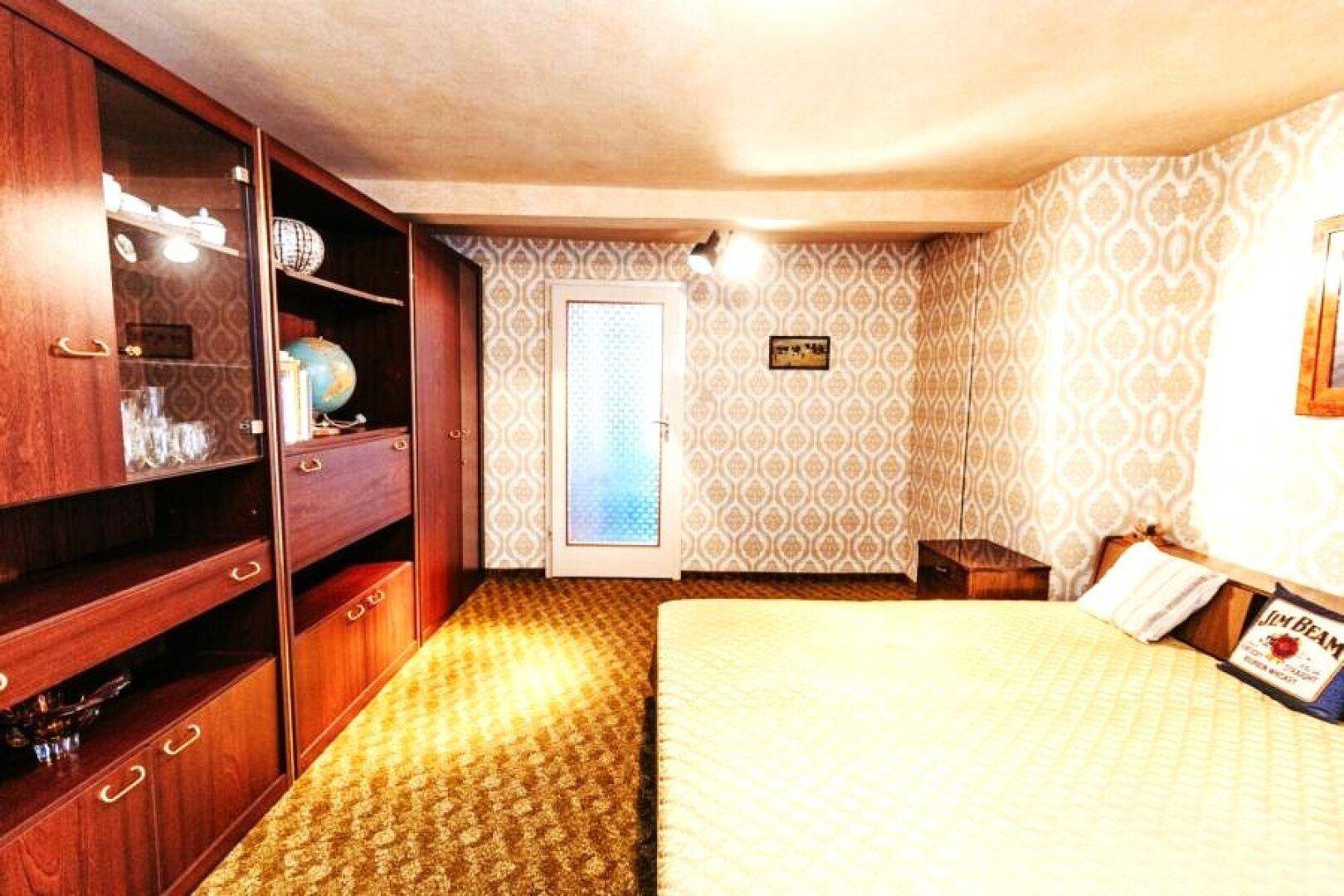 Schlafzimmer mit Doppelbett, gemusterter Tapete und Teppichboden.