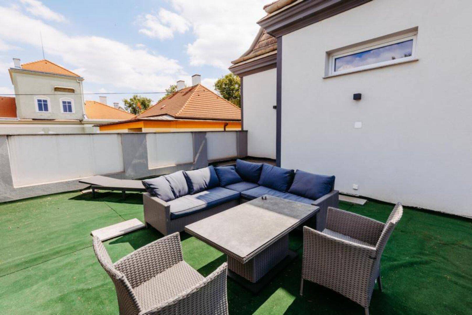 Geräumige Dachterrasse mit Kunstrasen und modernen Outdoor-Möbeln zum Entspannen.