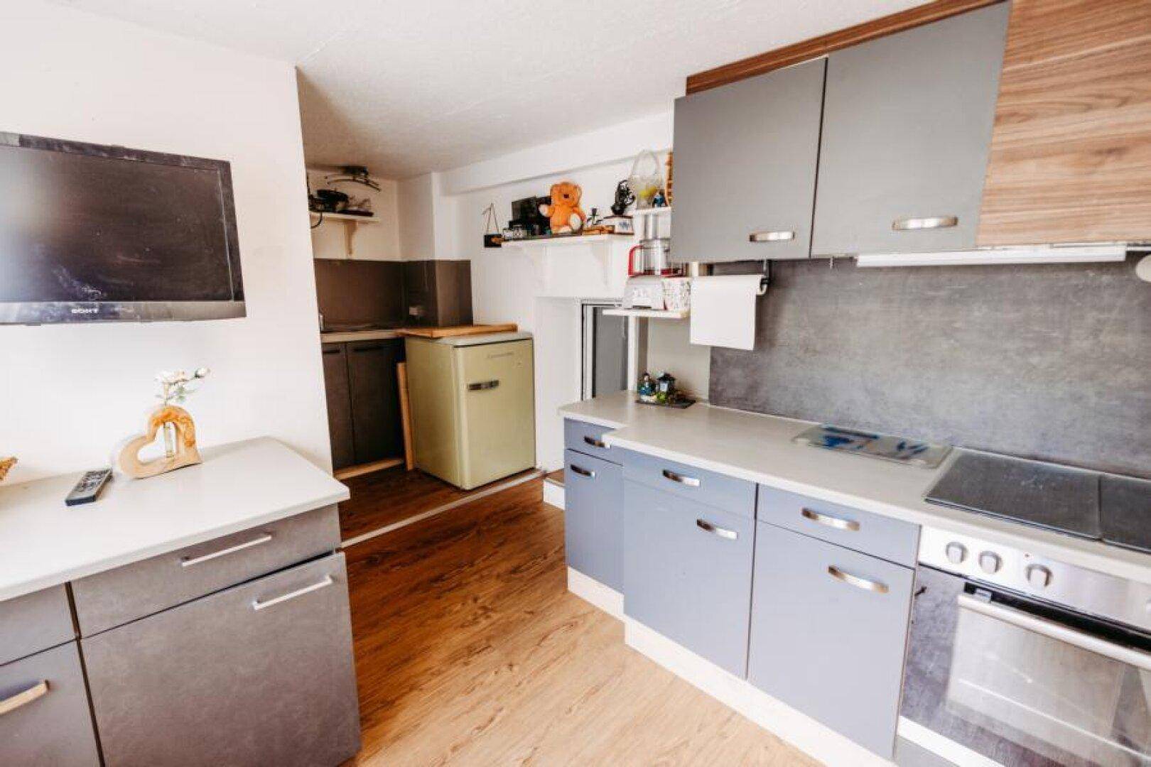Küche mit modernen Schränken, Retro-Kühlschrank und Kochfeld.