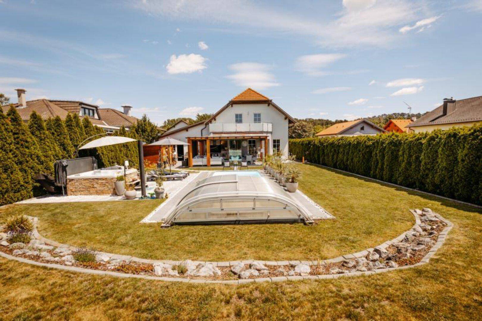 Weitläufige Ansicht des Anwesens mit Haus, großem Garten, Pool und umgebender grüner Landschaft.