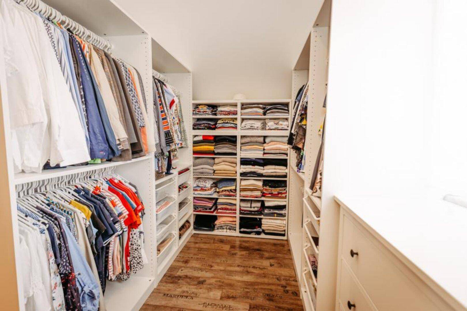 Geräumiger begehbarer Kleiderschrank mit viel Stauraum und organisierter Kleideraufbewahrung.