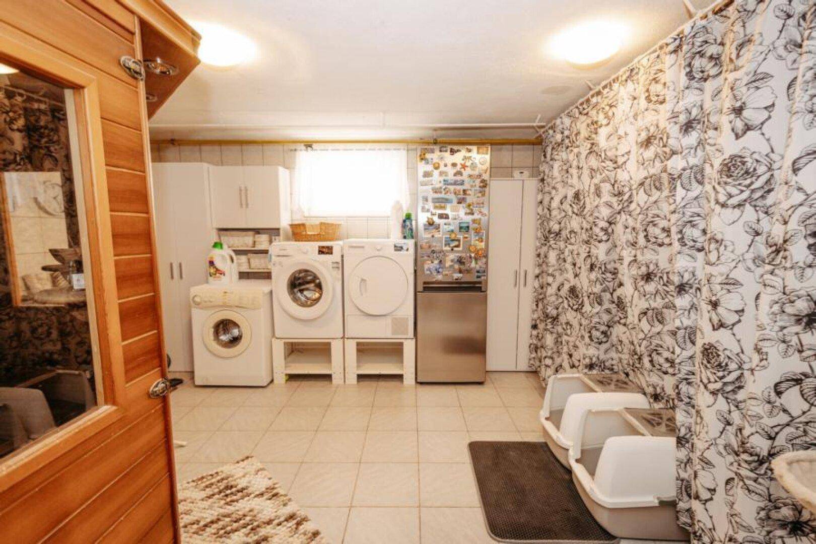 Waschküche mit Waschmaschinen, Trockner und integrierter Sauna.