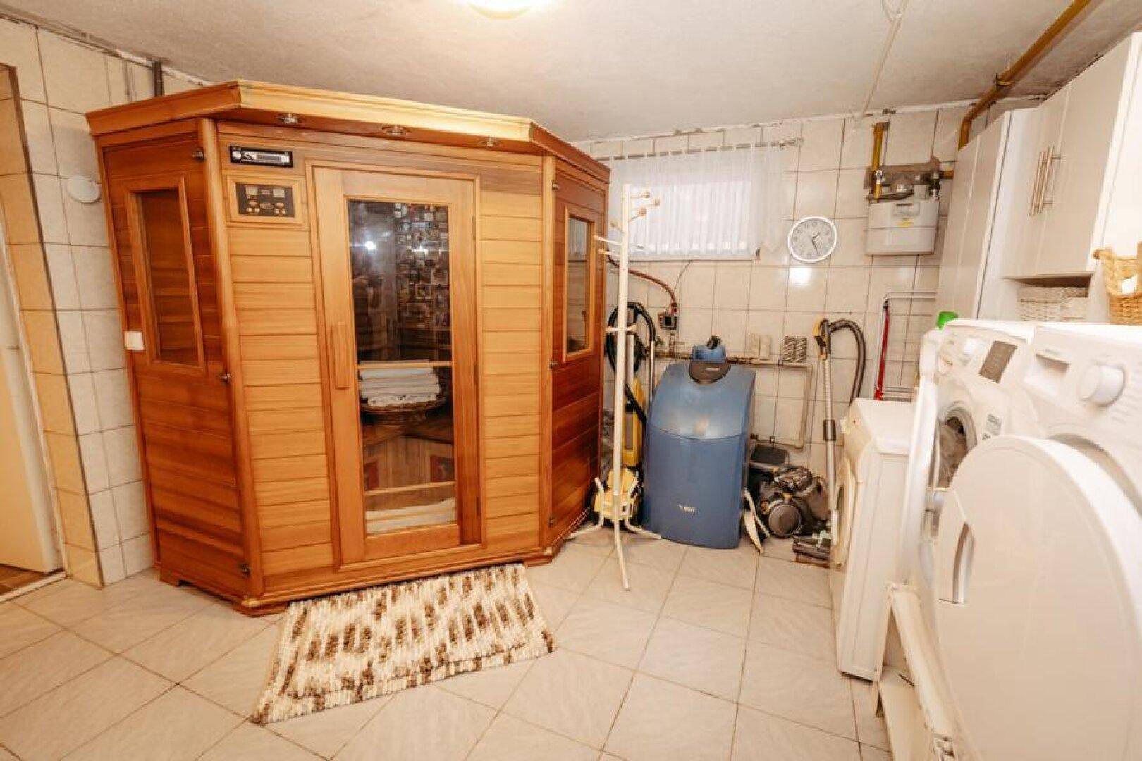 Hauswirtschaftsraum mit Sauna, Waschmaschinen und Heizungsinstallationen.