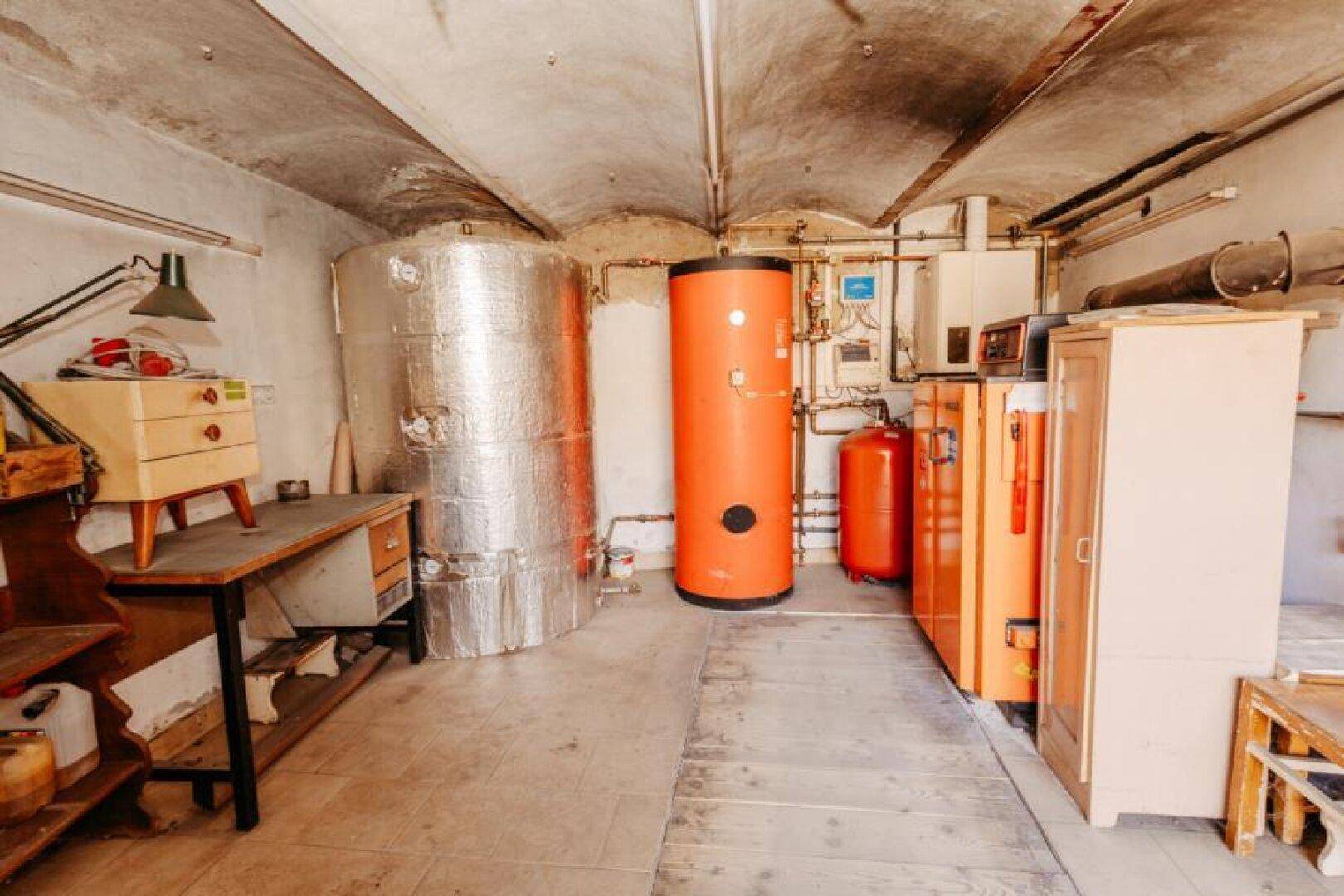 Kellerraum mit Heizungsanlagen, Warmwasserspeichern und Lagerflächen.