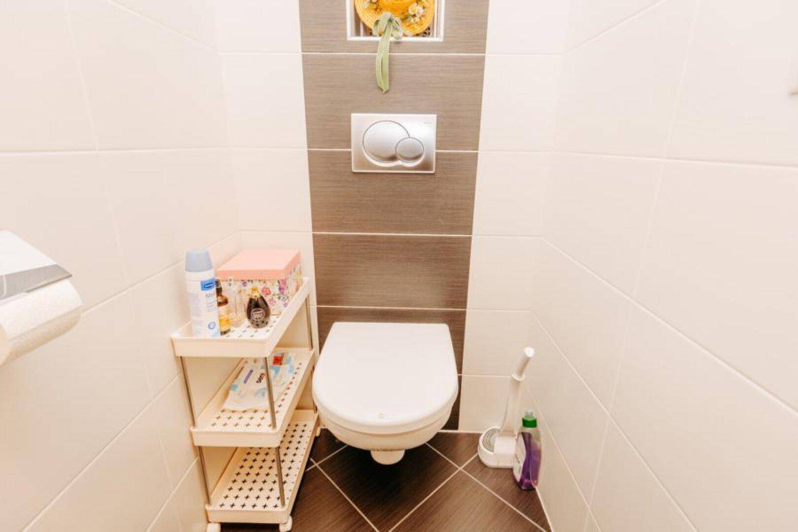 Kleines Gäste-WC mit wandhängender Toilette und modernen Fliesen in neutralen Farben.
