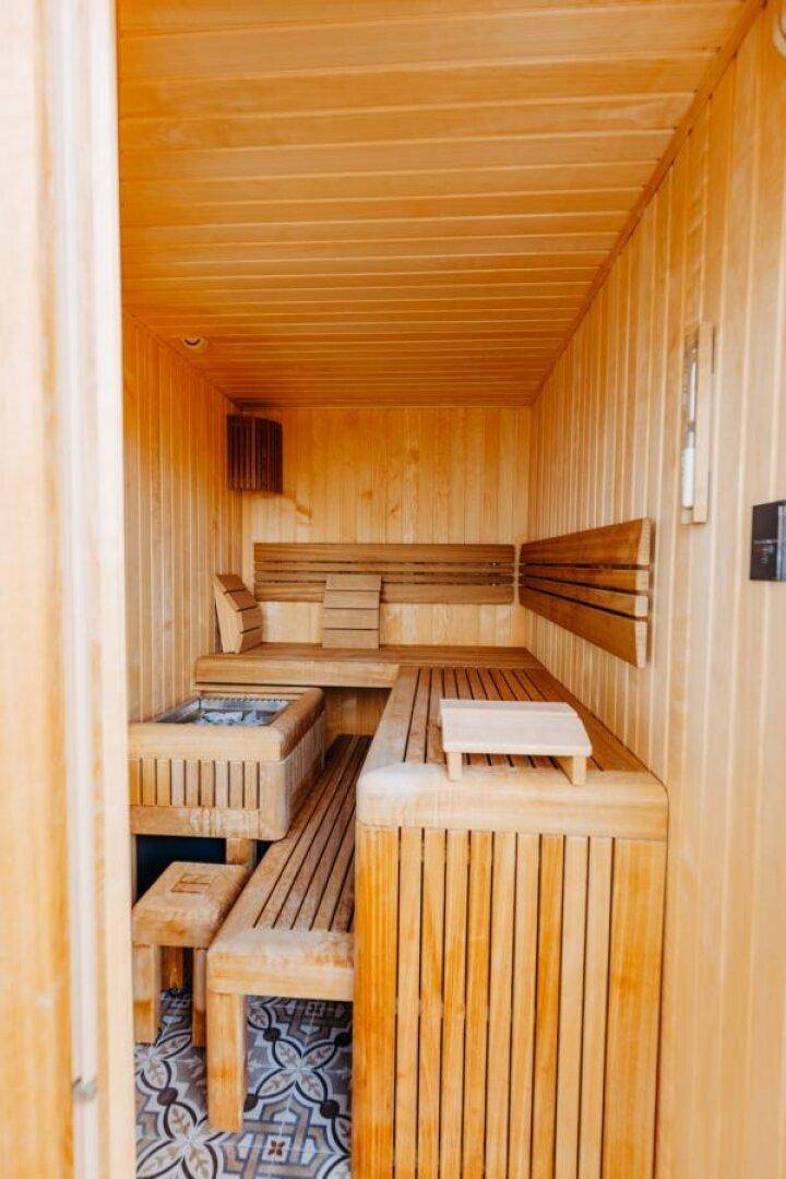 Innenansicht der Sauna mit Holzvertäfelung und bequemen Sitzbänken für Entspannung.