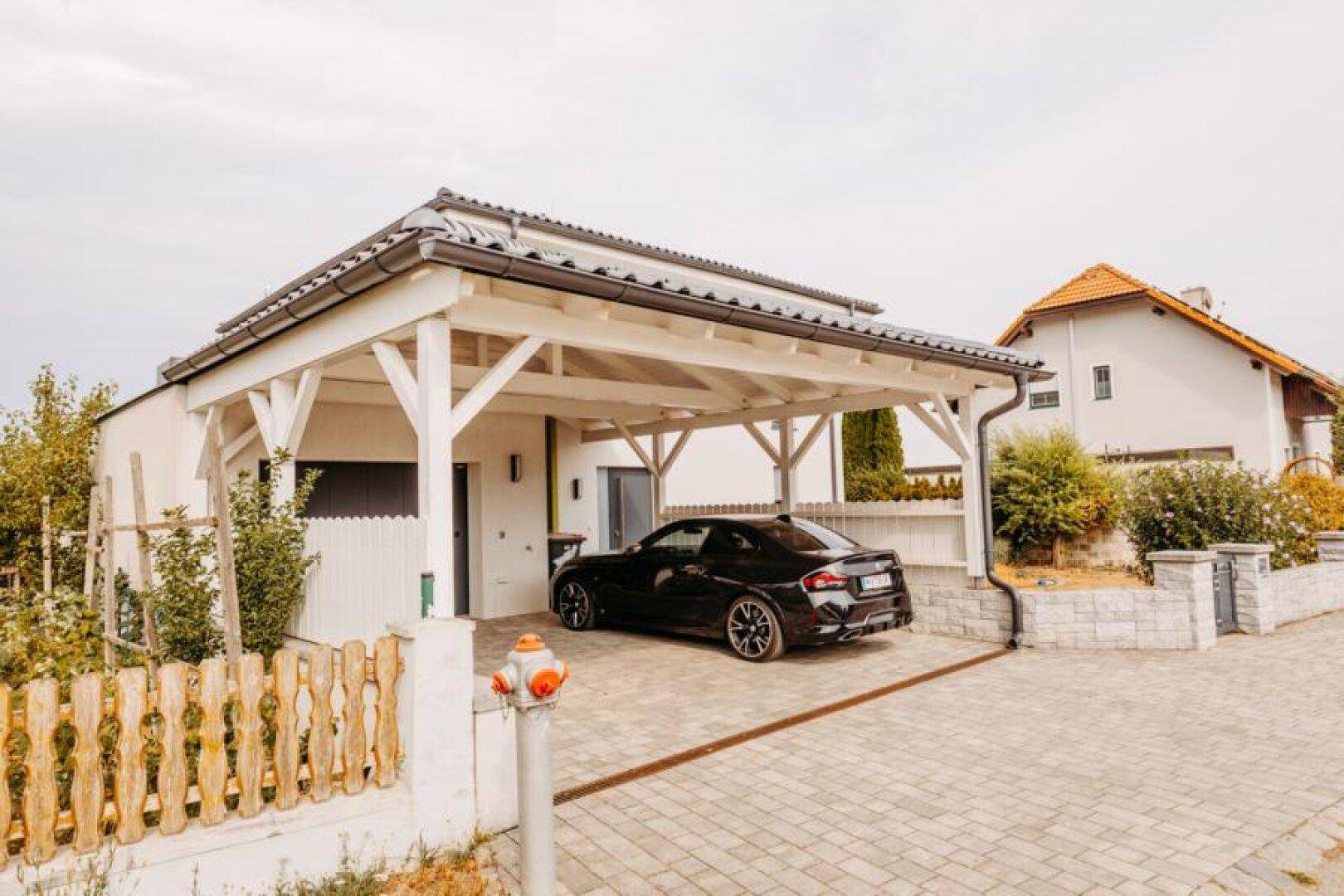 Modernes Haus mit Carport und gepflasterter Einfahrt, bietet bequemen Parkplatz.