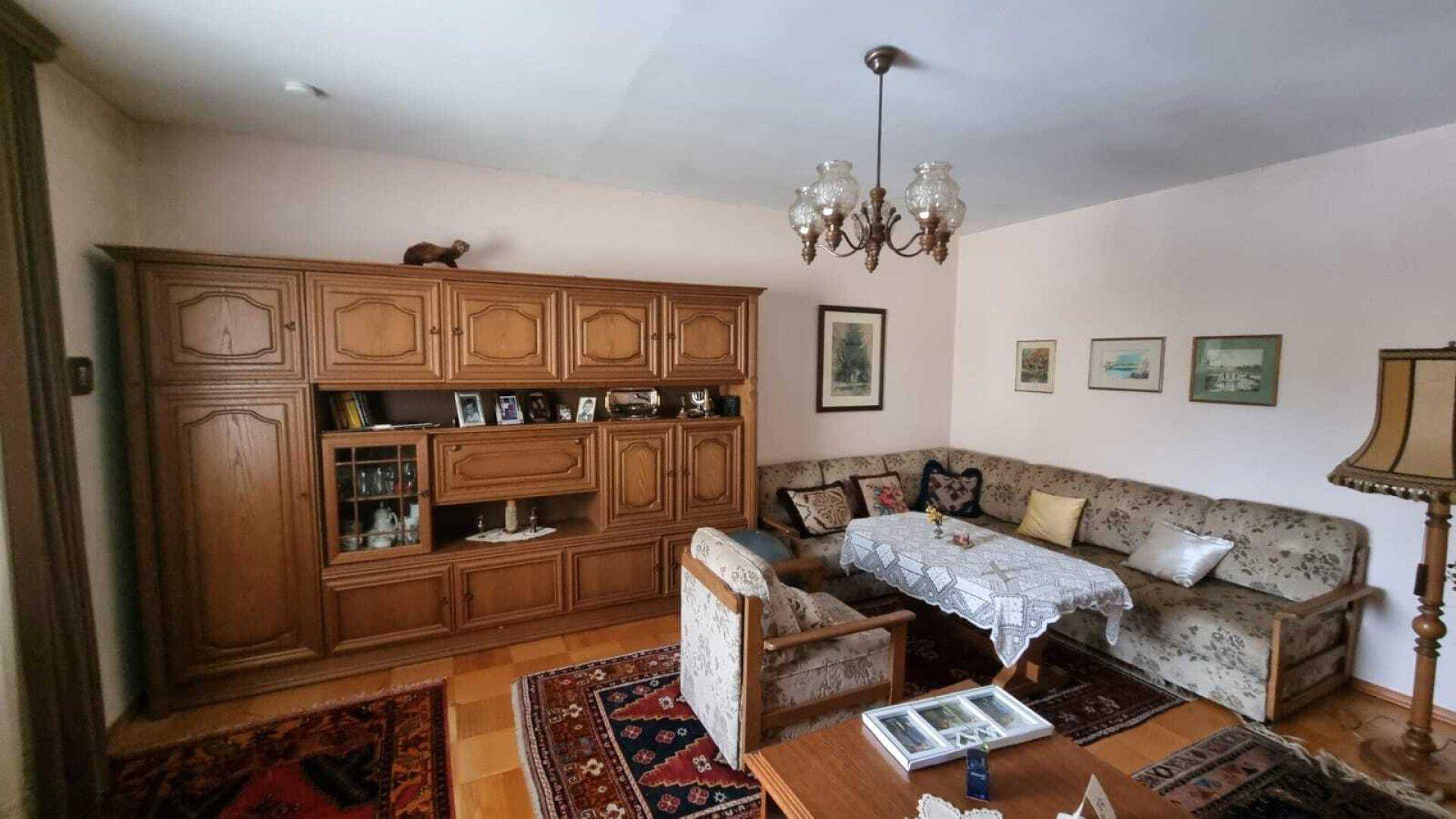 Geräumiges Wohnzimmer mit großer Eckbank, Holzwandmöbeln und einem Esstisch.