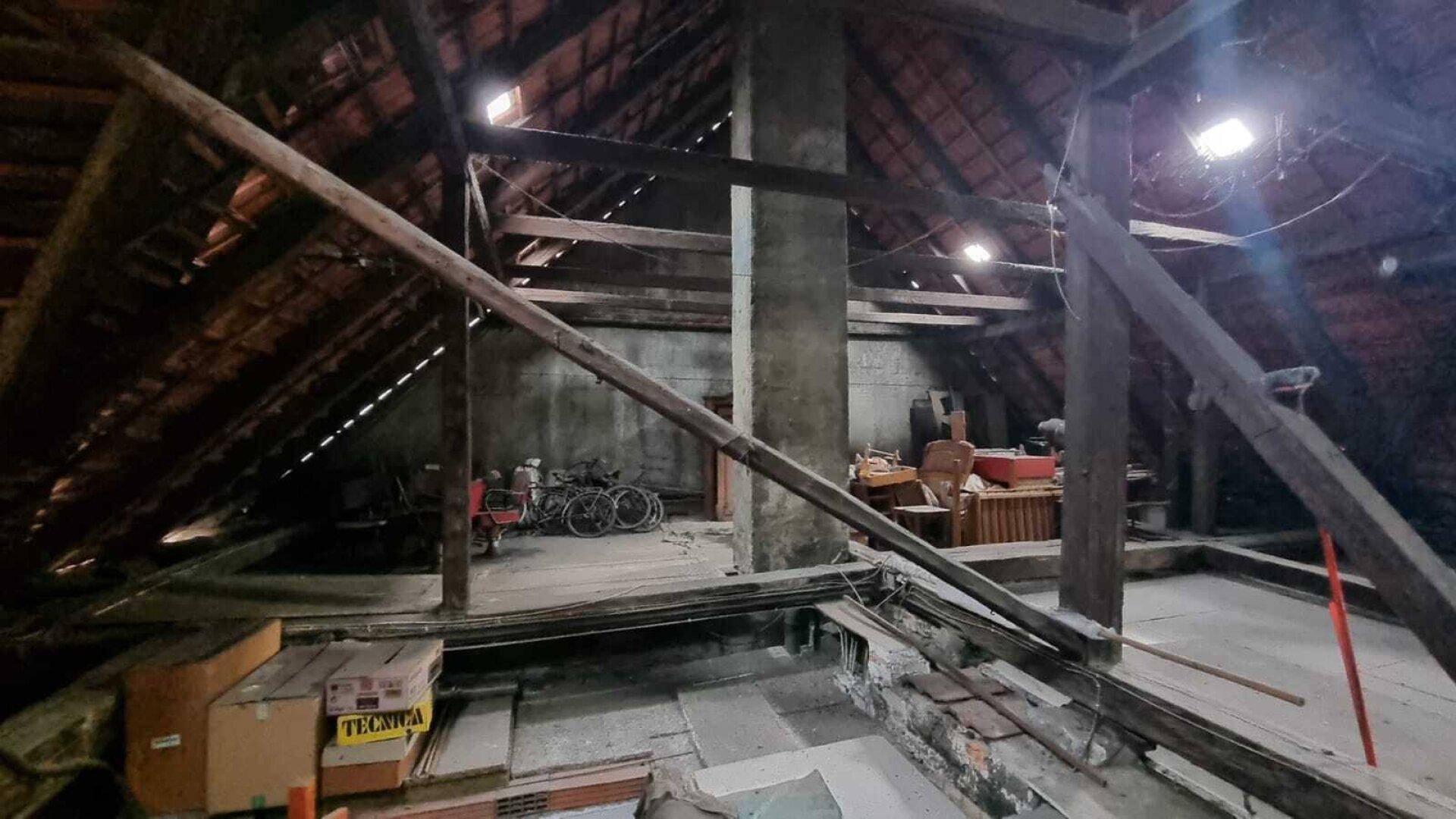 Geräumiger Dachboden mit sichtbaren Holzbalken, der als Lagerraum genutzt wird.