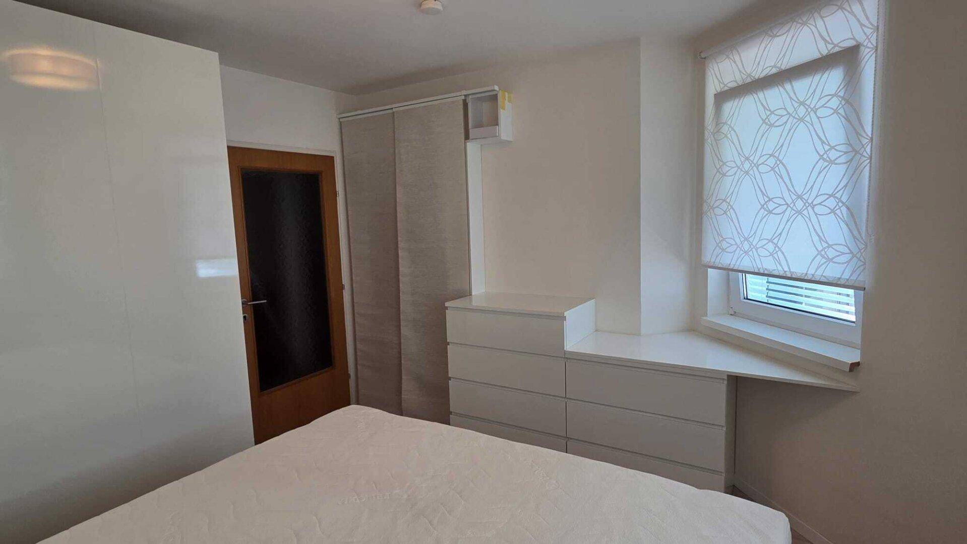 Schlafzimmer mit integrierten Schränken und Kommode, die den Raum optimal nutzen.