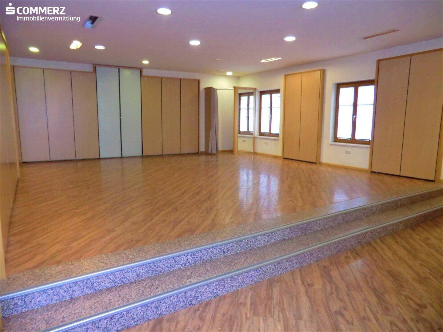 Großer, heller Raum mit Holzoptik-Boden und Einbauschränken, ideal für flexible Nutzung.