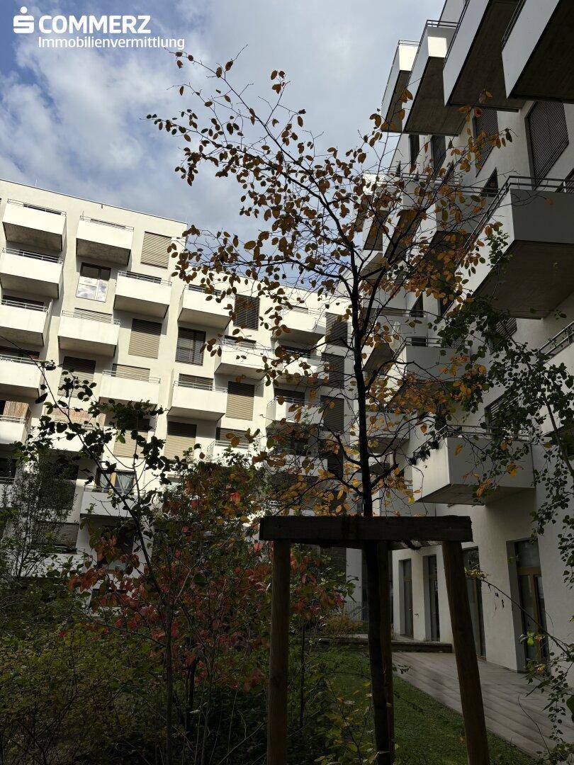 Moderner Apartmentkomplex mit zahlreichen Balkonen und einem begrünten Innenhofbereich.
