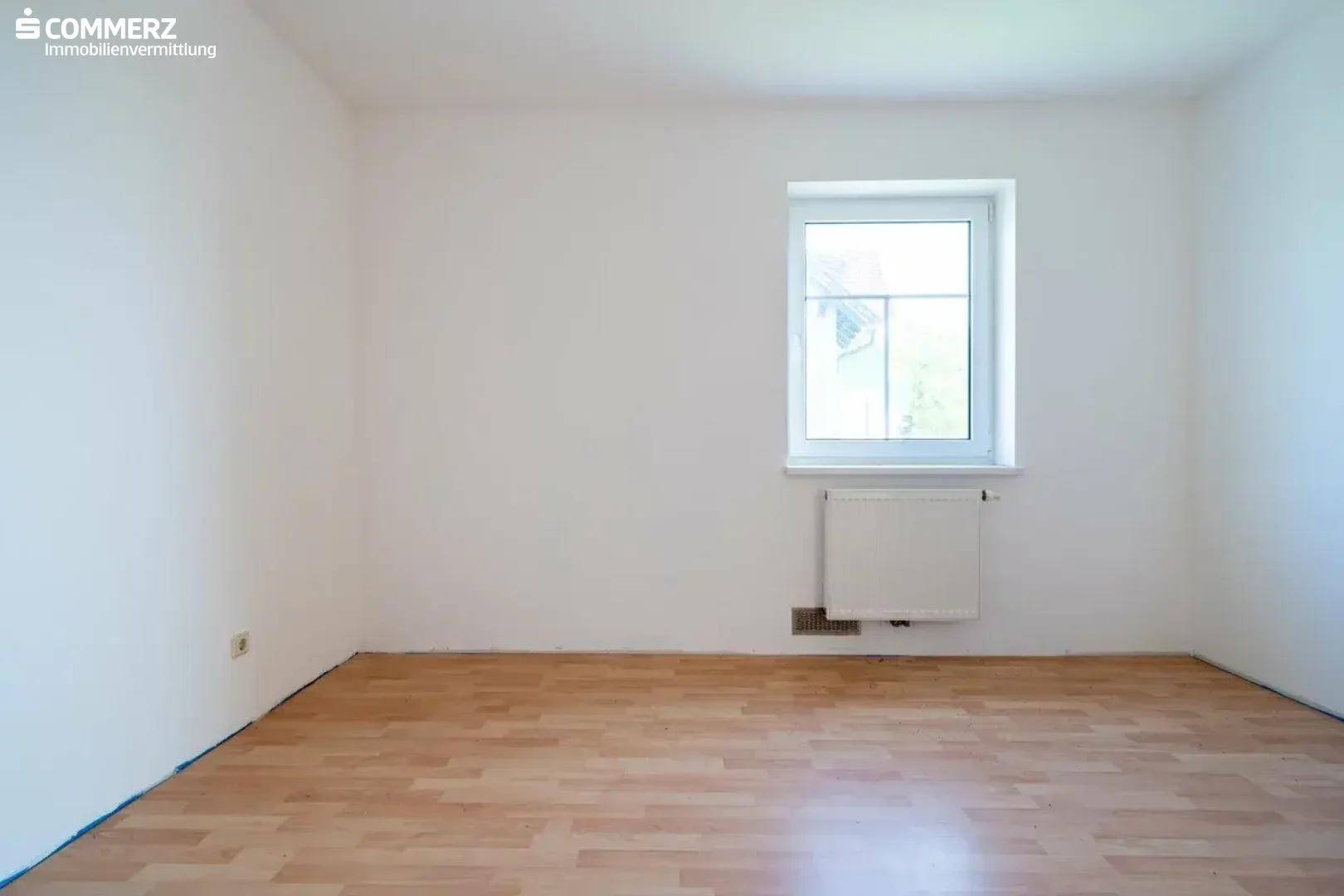 Weiteres helles Zimmer mit Laminatboden und Fenster, ideal als Kinder- oder Arbeitszimmer.