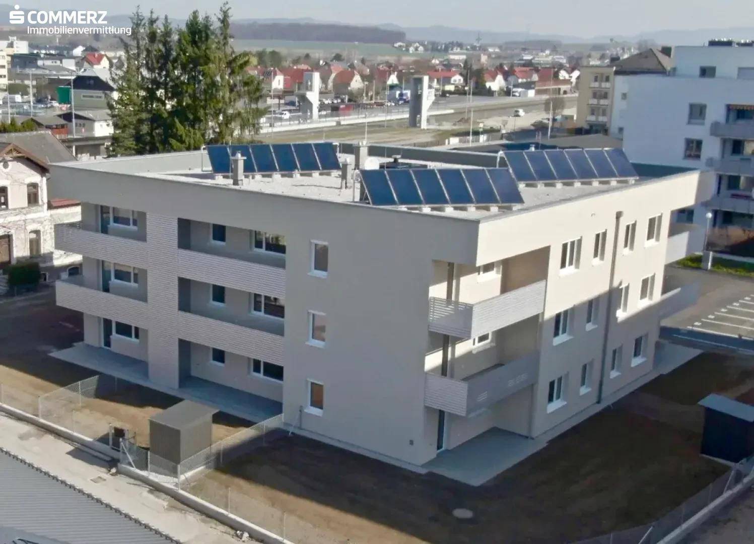 Modernes Wohngebäude mit Flachdach und installierter Photovoltaikanlage zur Energiegewinnung.