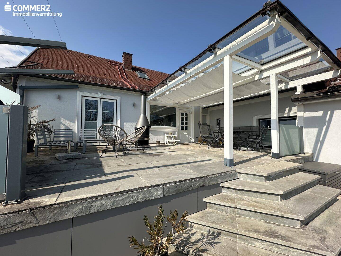 Geräumige Terrasse mit modernen Gartenmöbeln und Überdachung, ideal für entspannte Stunden im Freien.