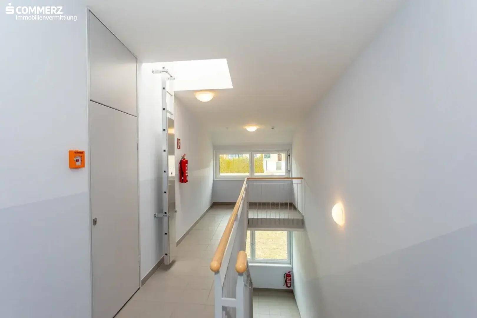 Heller Flur mit Treppenhaus, Oberlicht und weiß gestrichenen Wänden, gut beleuchtet.