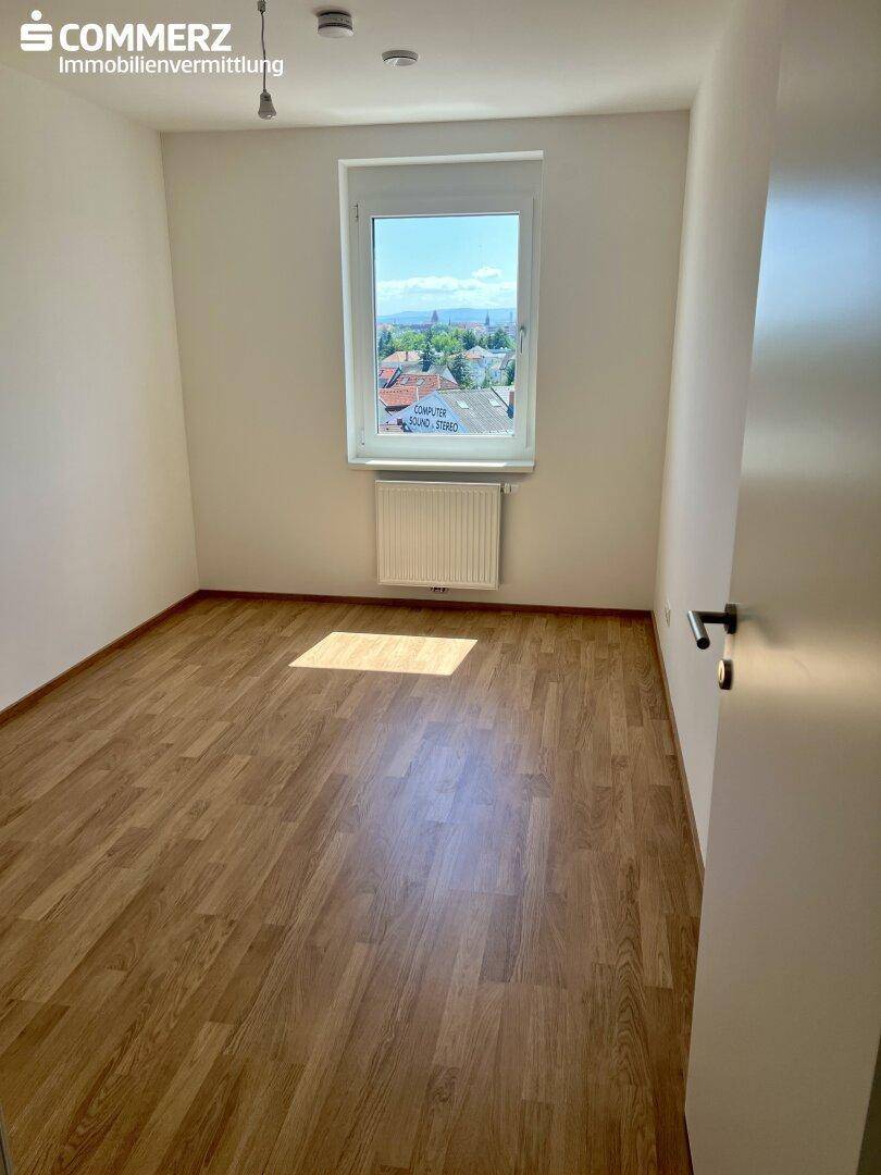 Weiteres helles Zimmer mit Laminatboden und Fenster, ideal als Kinder- oder Arbeitszimmer.