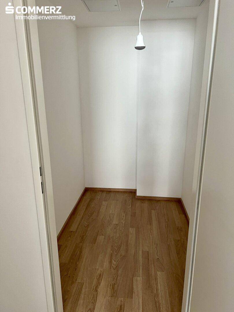 Kleiner Abstellraum mit Laminatboden und weißen Wänden, ideal für zusätzlichen Stauraum.