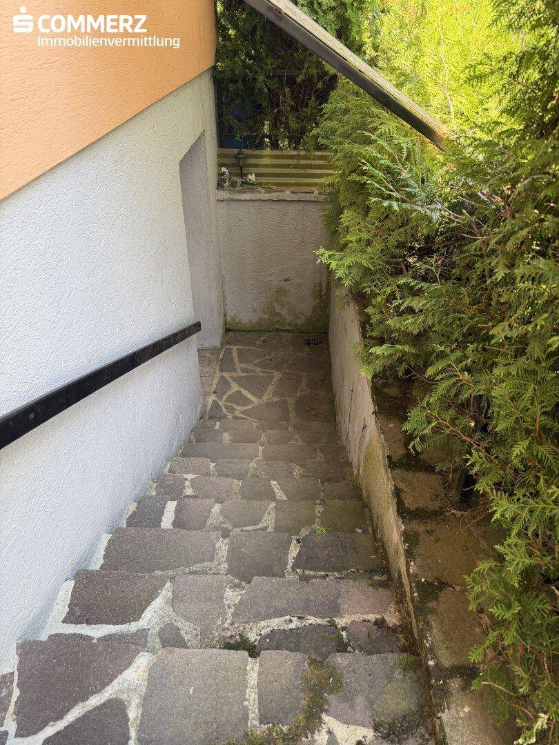 Steintreppe führt hinunter zum Kellerzugang des Hauses.