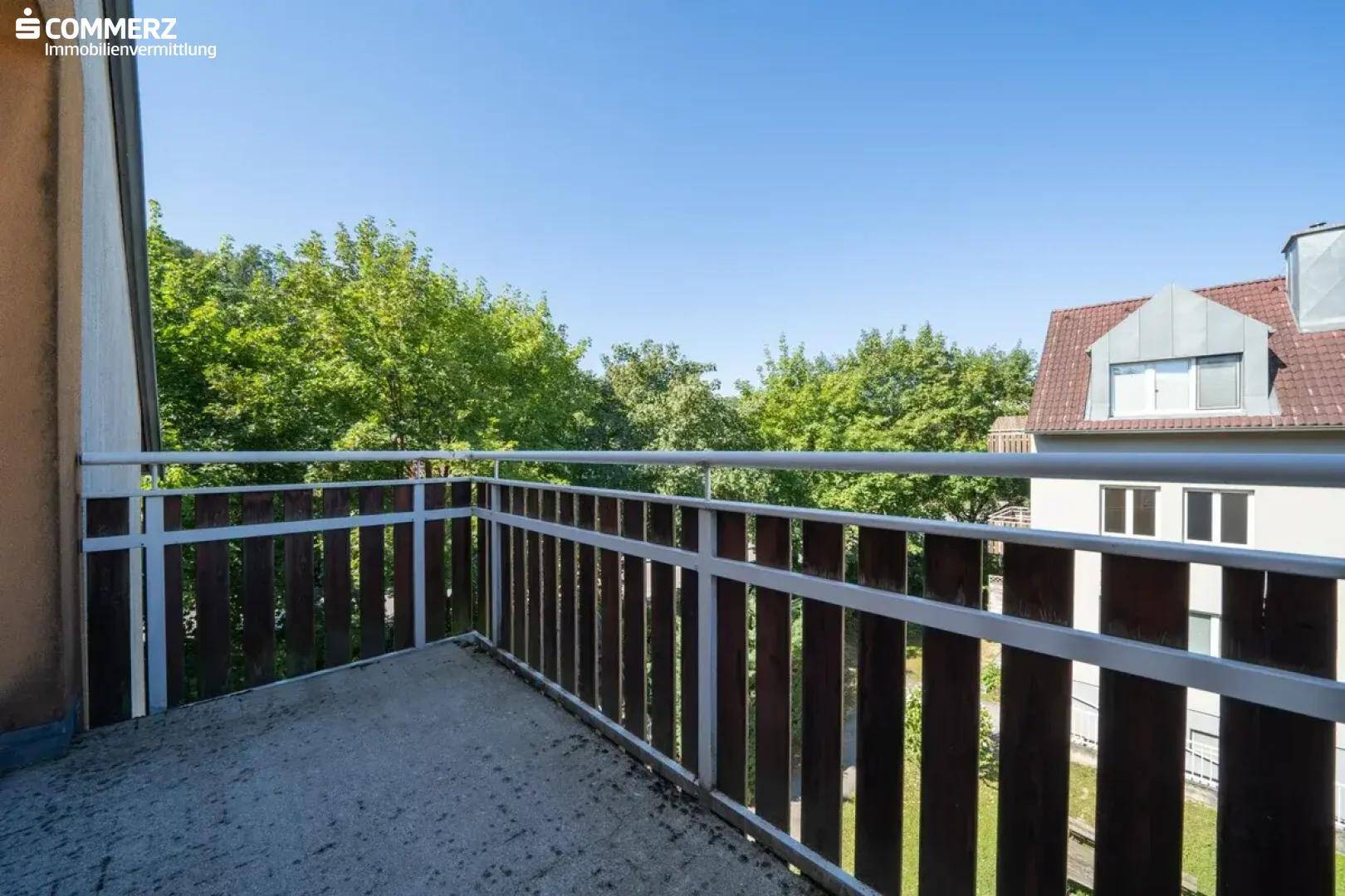 Kleiner Balkon mit Metallgeländer und Blick auf die umliegende grüne Landschaft.