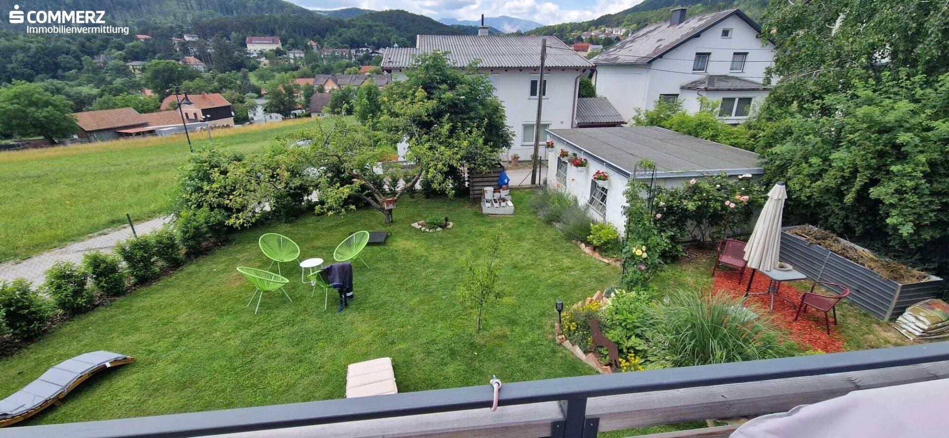 Großer, gepflegter Garten mit Rasenfläche, Obstbäumen und Sitzgelegenheiten im Freien.