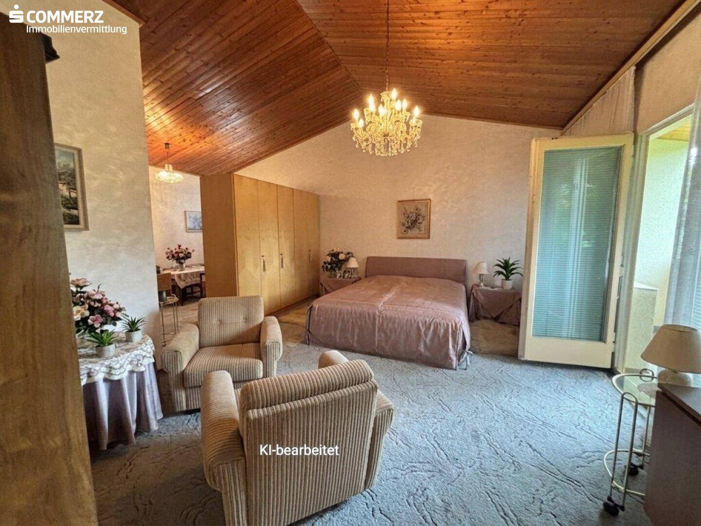 Geräumiges Schlafzimmer mit Doppelbett, Sitzgelegenheiten, Holzbalkendecke und Balkonzugang.