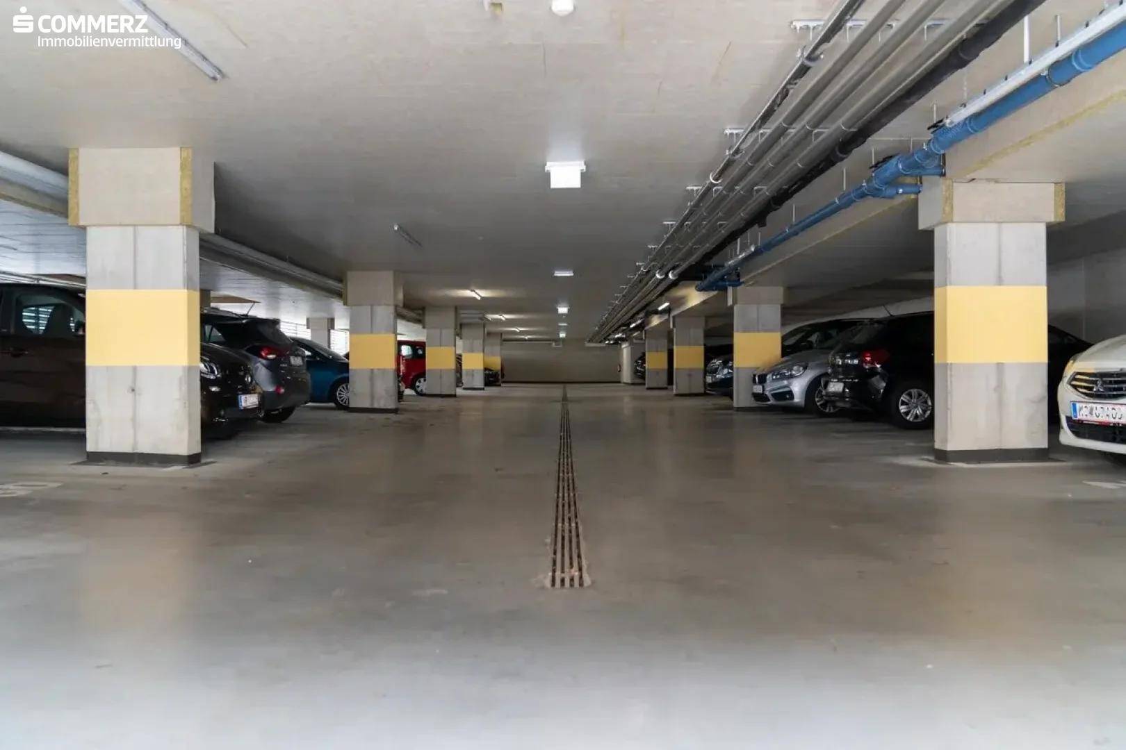 Tiefgarage mit zahlreichen Stellplätzen für Fahrzeuge, gut beleuchtet und geräumig.