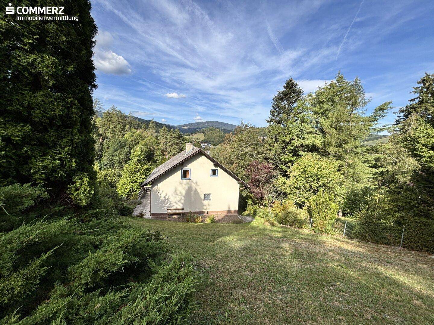 Freistehendes Haus in ländlicher Umgebung mit weitem Blick auf die bewaldeten Hügel.