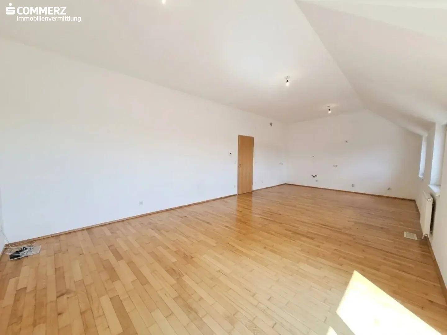 Heller Wohnbereich mit Holzboden, Dachschrägen und viel Platz für individuelle Einrichtungsideen.