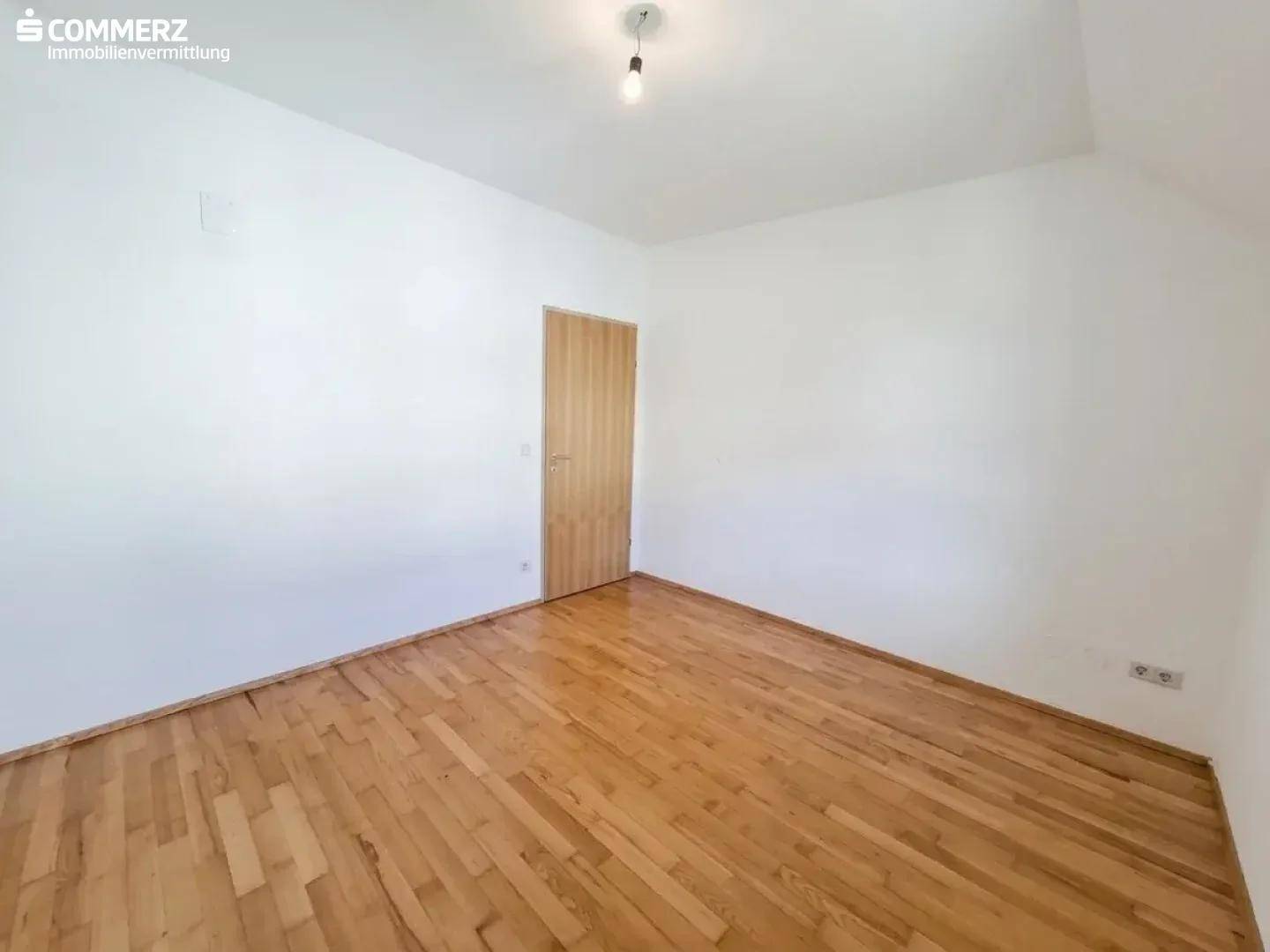 Schlafzimmer mit Holzboden und einer Holztür, bietet eine ruhige und private Atmosphäre.
