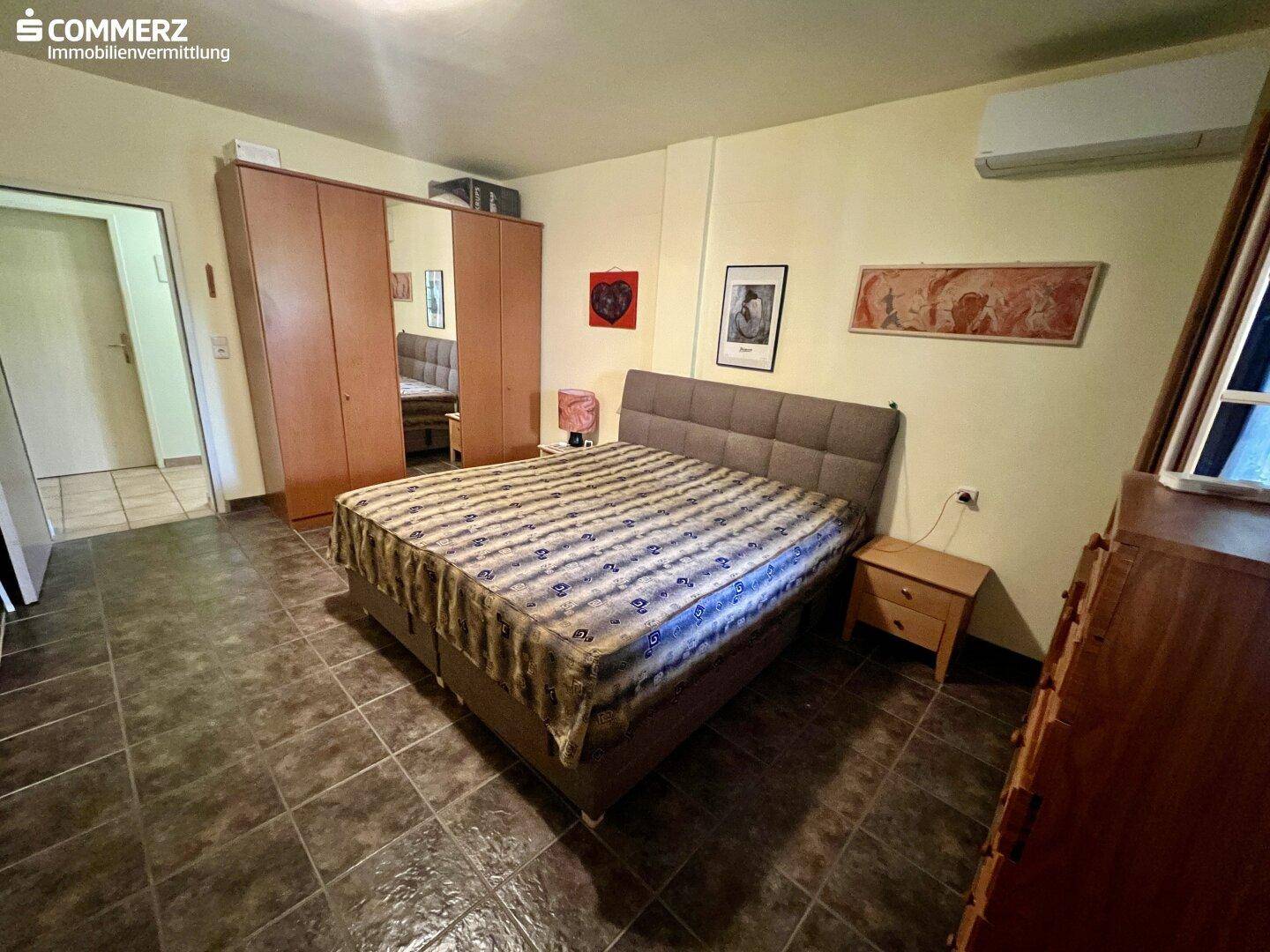 Helles Schlafzimmer mit großem Bett, Kleiderschrank und Klimaanlage, bietet viel Platz.