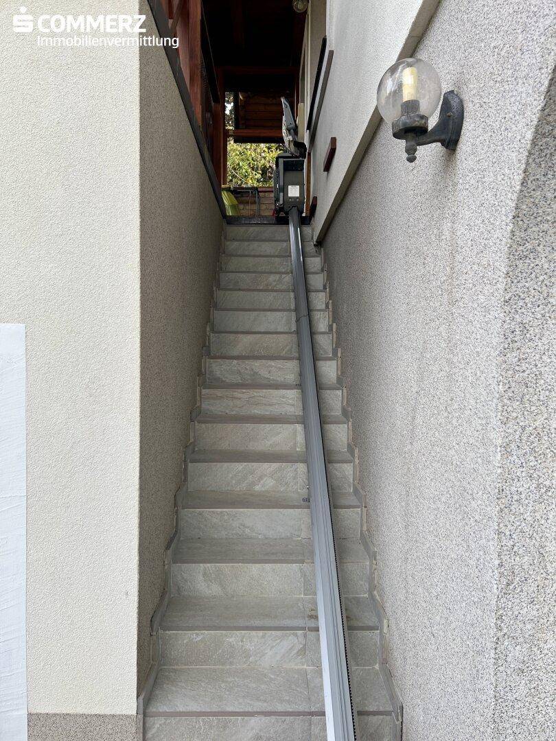 Außentreppe mit installiertem Treppenlift, der den Zugang zum oberen Bereich erleichtert.