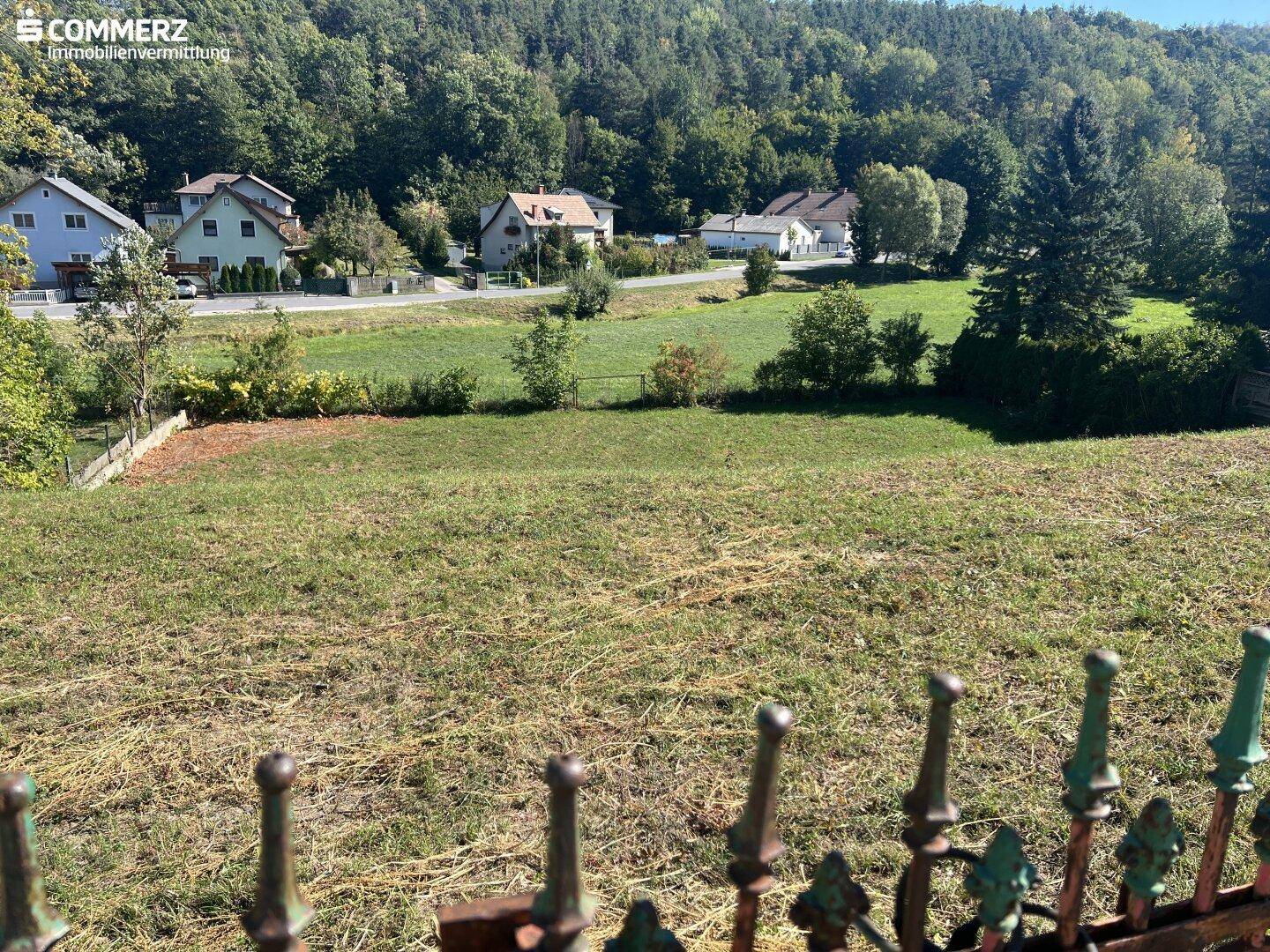 Weitläufiges, sonniges Grundstück mit Blick auf die umliegende grüne Landschaft und Wohnbebauung.