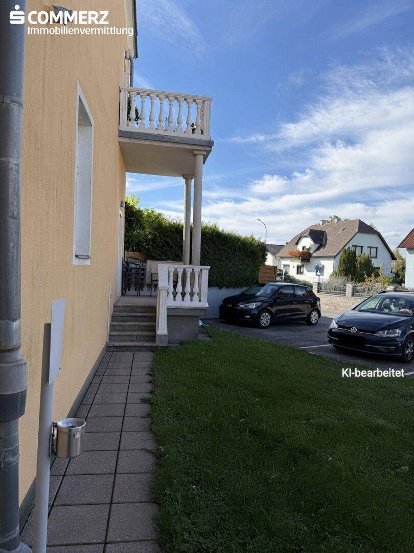 Seitenansicht des Hauses mit kleinem Balkon und Zugang zur Straße.