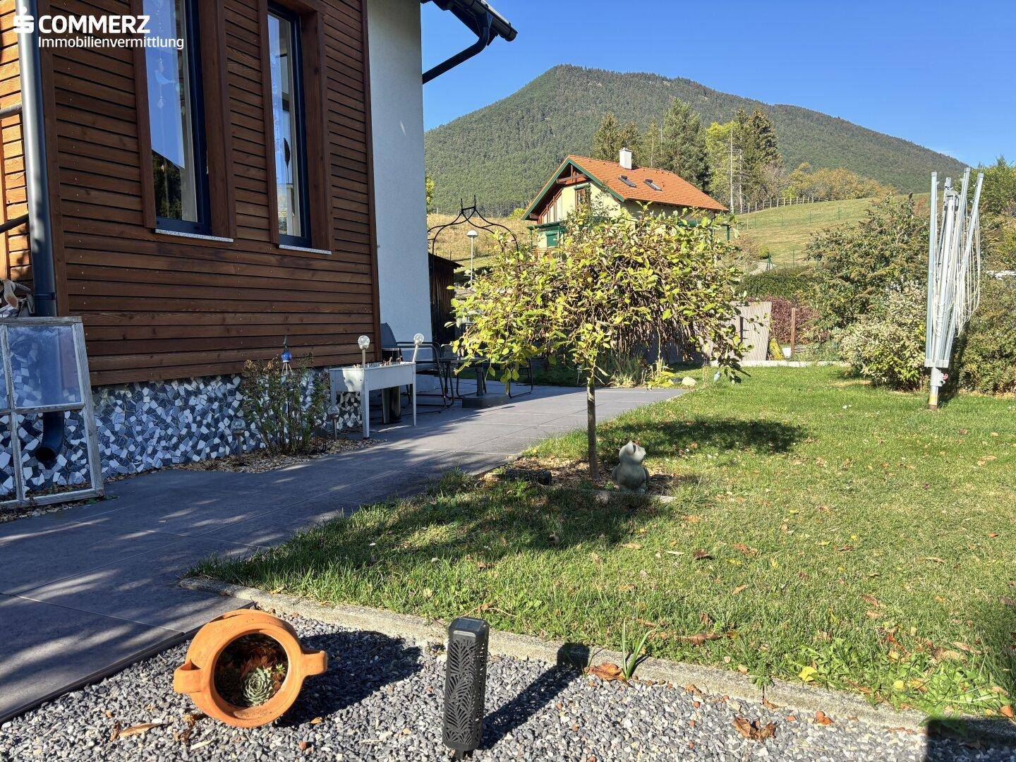 Sonnige Gartenseite des Hauses mit Blick auf die umliegende Berglandschaft.