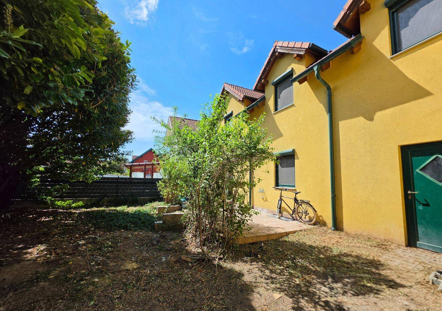Kleiner Gartenbereich mit Terrasse und viel Grün, ideal zum Entspannen im Freien.