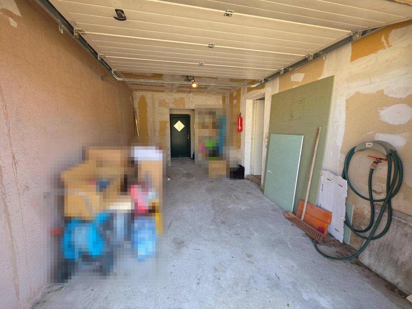 Innenansicht der Garage mit Betonboden und Lagerflächen.