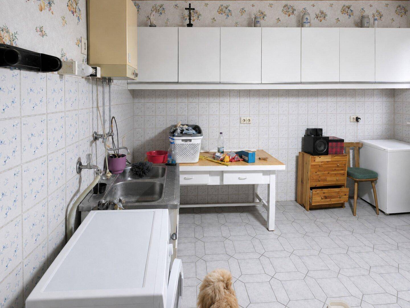 Hauswirtschaftsraum mit Spülbecken, Waschmaschine und Gefrierschrank.